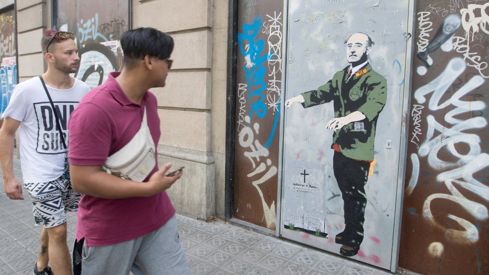 Dos jóvenes pasan ante el nuevo grafiti del artista urbano TVBoy. MARTA PÉREZ (EFE)