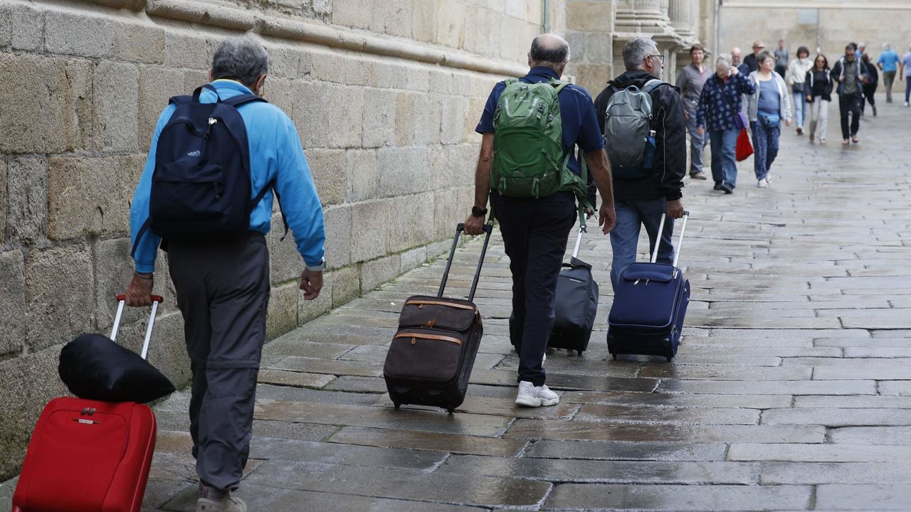 Turistas con maletas caminan por Santiago. EFE