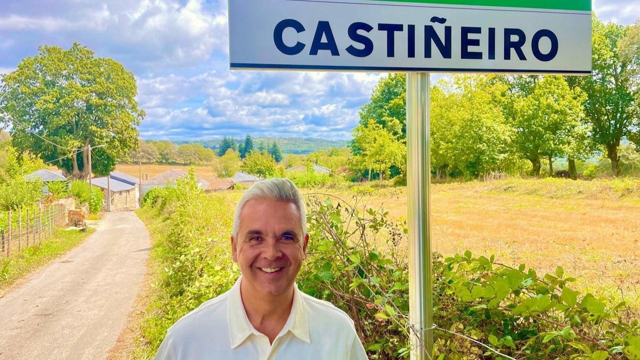 Juan Carlos Pérez junto al cartel con el nombre de la aldea de Castiñeiro, donde surgió la idea de Aldealista. EP