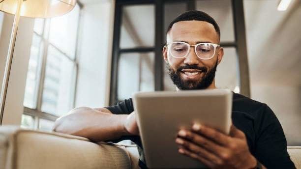 Black man, tablet and smile for social media post, shopping online or browsing internet creative content at home. Young africa american happy, relax and calm on tech digital app on device